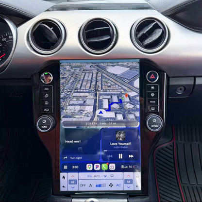 A large vertical touchscreen infotainment and navigation display installed in the center console of a car interior, with climate controls and air vents visible around it.