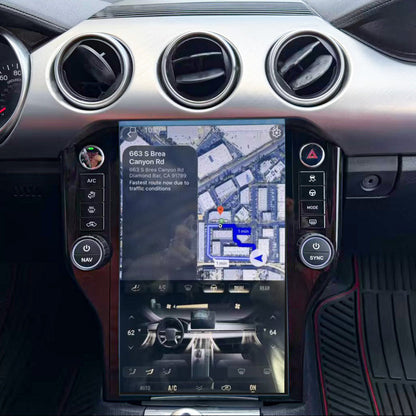 A close-up of a car's dashboard and center console, featuring a large vertical touchscreen display showing a map and vehicle controls, with circular air vents and silver trim.