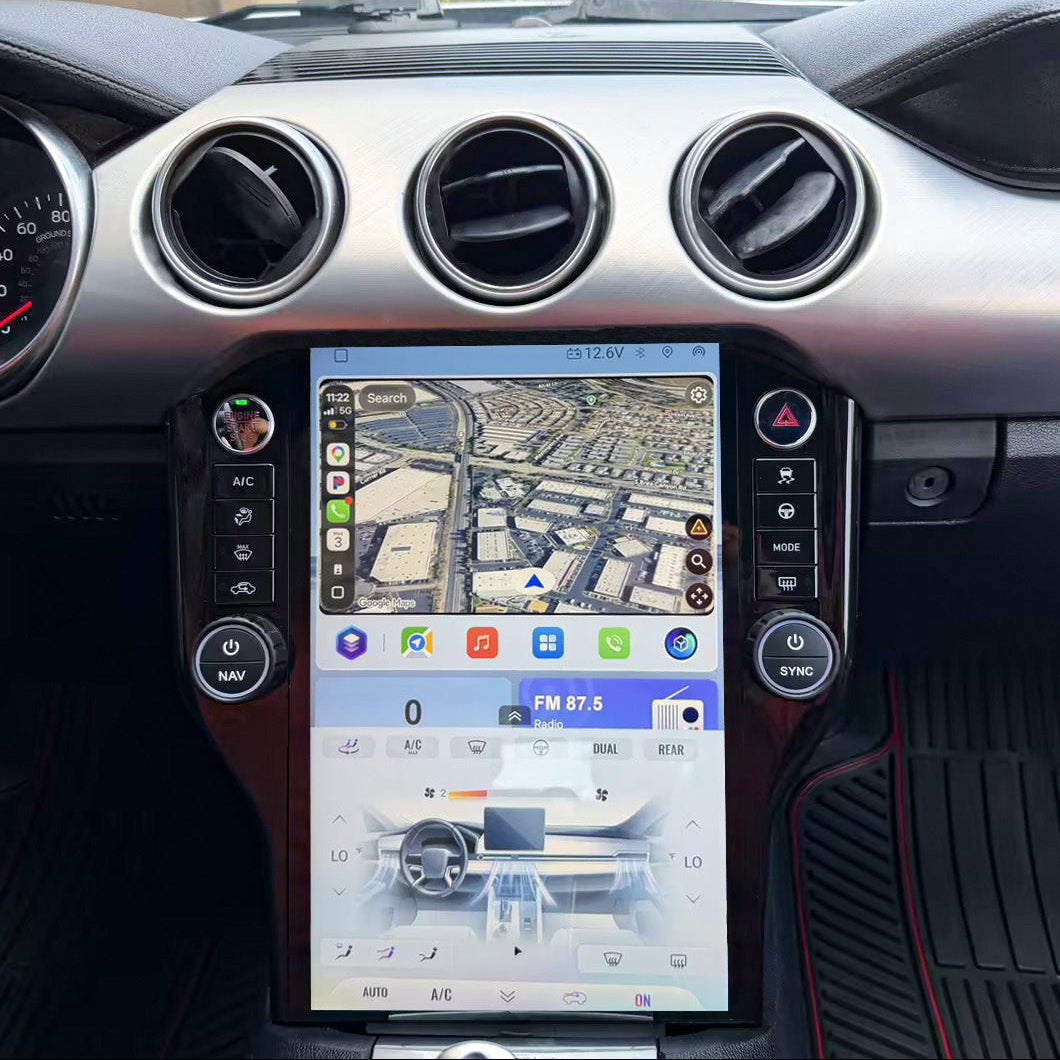A large vertical touchscreen infotainment display mounted in the center console of a car interior, showing a map and vehicle control icons, with air vents and dashboard visible around it.